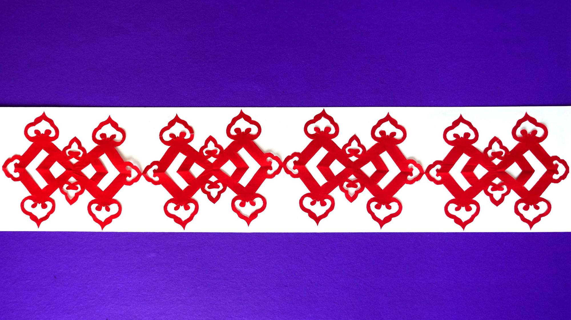 1方胜纹剪纸:选用长条状的纸,先对折成正方形,然后画上图案,剪下来就