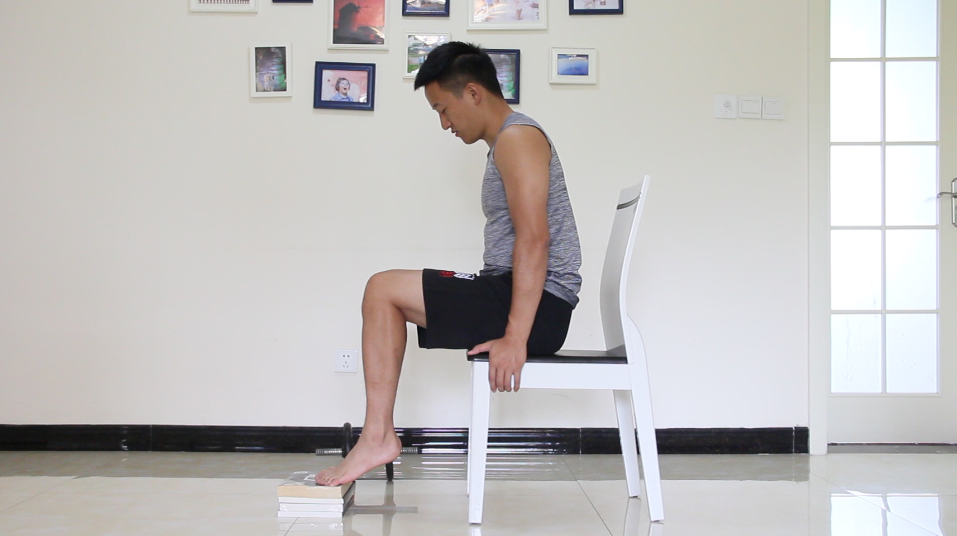 2坐姿提踵运动,注意将前脚掌置于书的上面,保持小腿垂直地面,大腿与